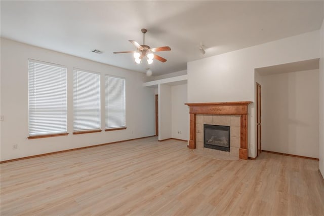 2412 NW 164th Ter, Edmond, OK 73013 - unfurnished living room with ceiling fan, wood finished floors, and a tiled fireplace