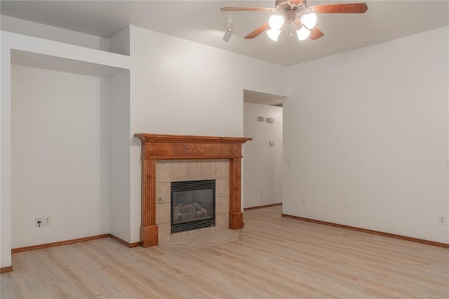 2412 NW 164th Ter, Edmond, OK 73013 - unfurnished living room featuring a ceiling fan, wood finished floors, and a tiled fireplace