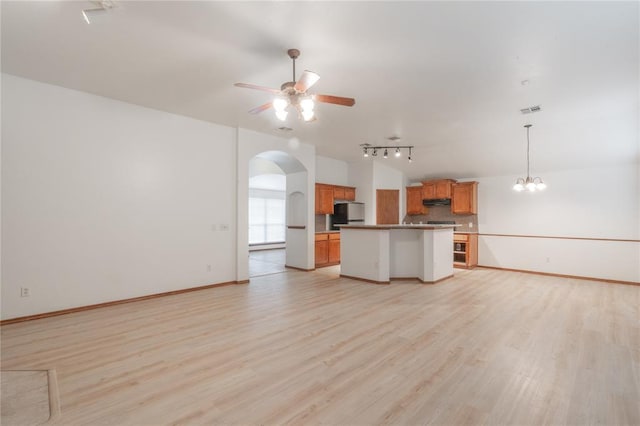 2412 NW 164th Ter, Edmond, OK 73013 - unfurnished living room with a ceiling fan, arched walkways, light wood-style flooring, track lighting, and a chandelier