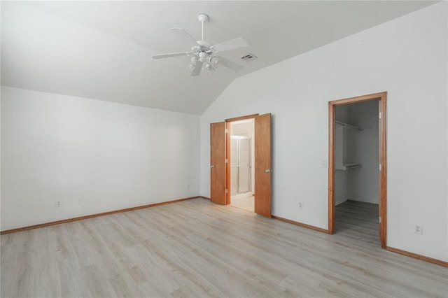 2412 NW 164th Ter, Edmond, OK 73013 - unfurnished bedroom featuring lofted ceiling, a walk in closet, light wood finished floors, a closet, and ceiling fan