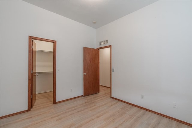 2412 NW 164th Ter, Edmond, OK 73013 - unfurnished bedroom featuring wood finished floors, a walk in closet, and a closet
