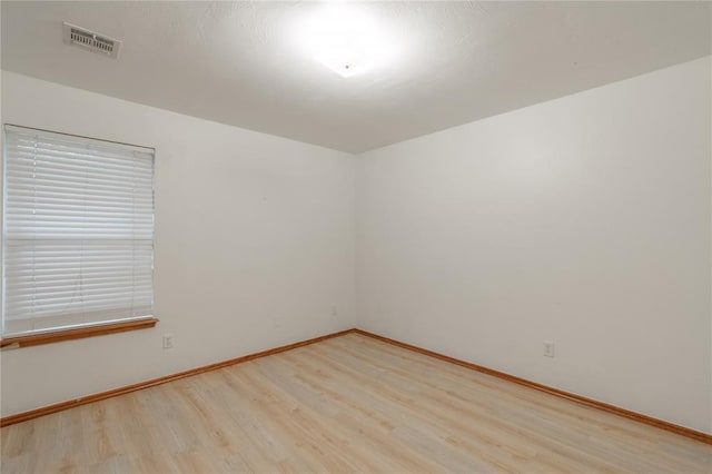 2412 NW 164th Ter, Edmond, OK 73013 - empty room with wood finished floors and healthy amount of natural light
