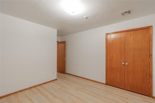 2412 NW 164th Ter, Edmond, OK 73013 - unfurnished bedroom featuring light wood finished floors and a closet