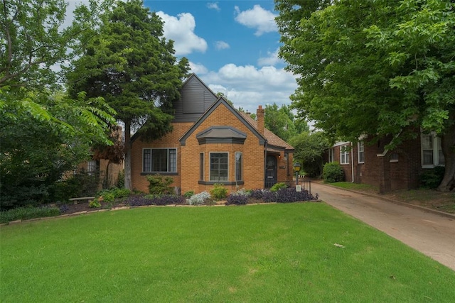 217 NW 30th St, Oklahoma City, OK 73118 - view of front of home with a front lawn, a chimney, brick siding, and driveway