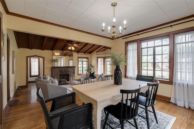 217 NW 30th St, Oklahoma City, OK 73118 - dining area featuring a chandelier, light wood-style floors, a premium fireplace, a ceiling fan, and ornamental molding