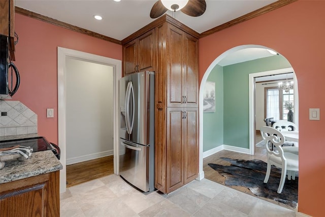 217 NW 30th St, Oklahoma City, OK 73118 - kitchen featuring stainless steel refrigerator with ice dispenser, arched walkways, brown cabinets, ornamental molding, and ceiling fan