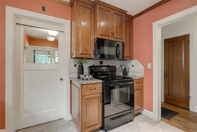 217 NW 30th St, Oklahoma City, OK 73118 - kitchen featuring black appliances, tasteful backsplash, brown cabinetry, light stone countertops, and crown molding