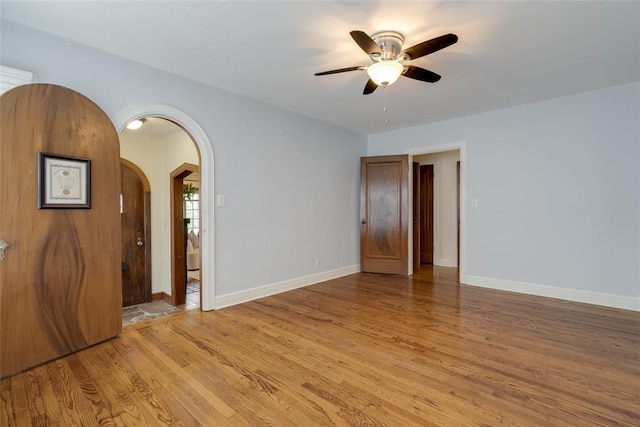 217 NW 30th St, Oklahoma City, OK 73118 - unfurnished room featuring ceiling fan, light wood-type flooring, and arched walkways