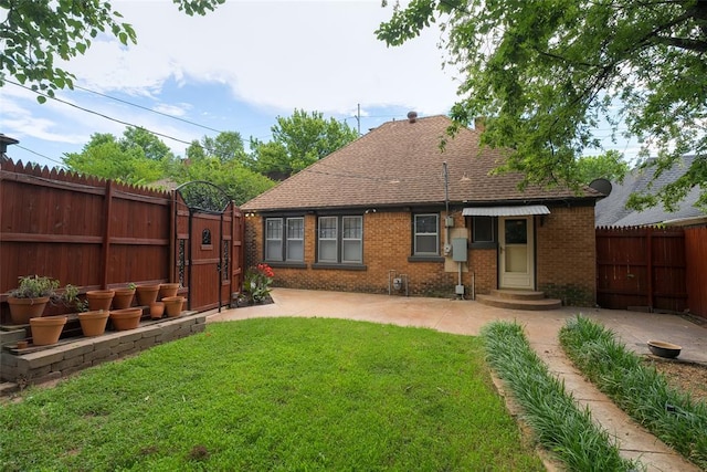 217 NW 30th St, Oklahoma City, OK 73118 - back of house with brick siding, a fenced backyard, a patio, a shingled roof, and entry steps
