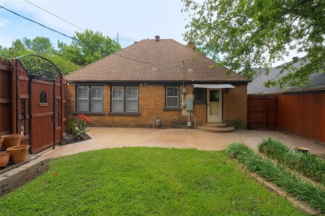 217 NW 30th St, Oklahoma City, OK 73118 - rear view of property featuring a gate, brick siding, a shingled roof, and a patio area
