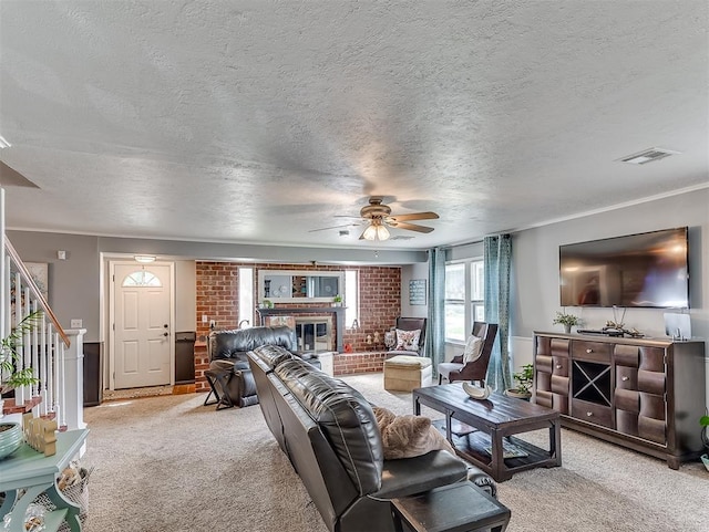 4603 N Wheeler Ave, Bethany, OK 73008 - living area with a brick fireplace, light carpet, ceiling fan, stairway, and a textured ceiling