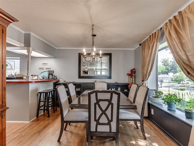4603 N Wheeler Ave, Bethany, OK 73008 - dining space featuring healthy amount of natural light, crown molding, light wood finished floors, and a chandelier