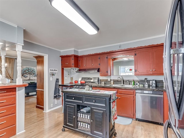 4603 N Wheeler Ave, Bethany, OK 73008 - kitchen with appliances with stainless steel finishes, under cabinet range hood, light wood-type flooring, dark countertops, and ornamental molding