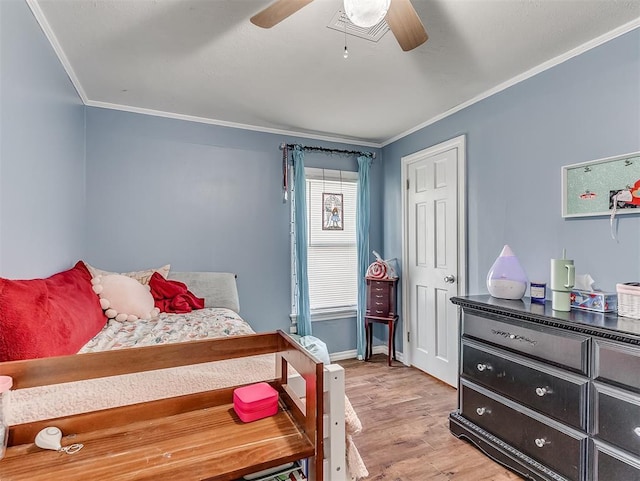 4603 N Wheeler Ave, Bethany, OK 73008 - bedroom with crown molding, light wood-style floors, and a ceiling fan