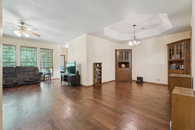 14601 Billy Dr, Edmond, OK 73034 - living room featuring a chandelier, a ceiling fan, dark wood-style flooring, and a raised ceiling