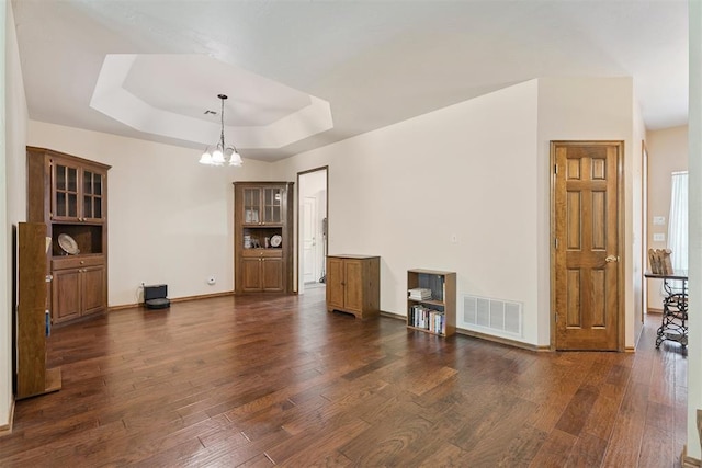 14601 Billy Dr, Edmond, OK 73034 - unfurnished living room with a chandelier, dark wood-style floors, and a tray ceiling