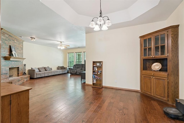14601 Billy Dr, Edmond, OK 73034 - living area with dark wood-style floors, a fireplace, a chandelier, and a ceiling fan