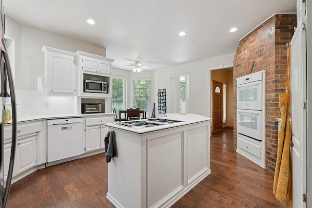 14601 Billy Dr, Edmond, OK 73034 - kitchen featuring white appliances, dark wood-type flooring, a ceiling fan, white cabinets, and a kitchen island