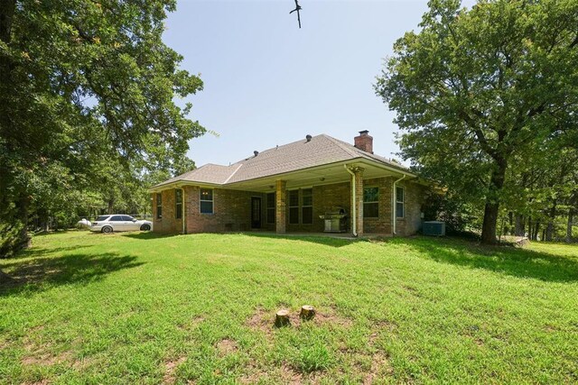 14601 Billy Dr, Edmond, OK 73034 - back of property featuring a chimney, a yard, and brick siding