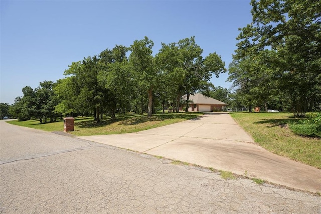 14601 Billy Dr, Edmond, OK 73034 - view of property hidden behind natural elements with concrete driveway, a front lawn, and view of scattered trees