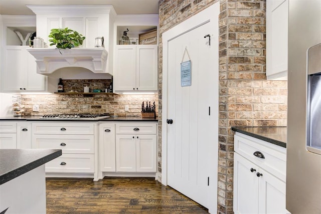 14716 Turkey Hills Rd, Newalla, OK 74857 - kitchen featuring dark countertops, stainless steel gas stovetop, dark wood-type flooring, tasteful backsplash, and white cabinetry