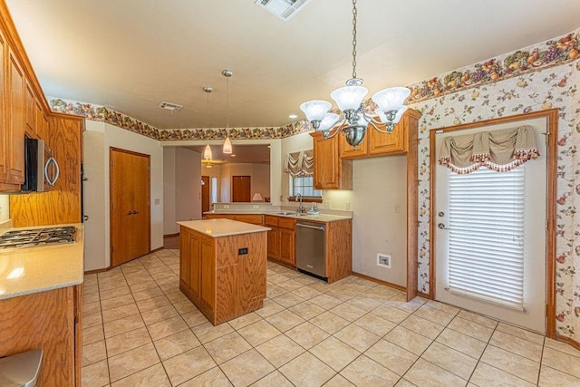 105 Kimberling Dr, Moore, OK 73160 - kitchen with stainless steel appliances, light countertops, a chandelier, light tile patterned flooring, and a center island