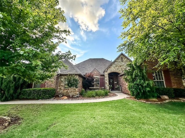 16721 Village Garden Dr, Edmond, OK 73012 - view of front of property with stone siding, a front yard, and brick siding