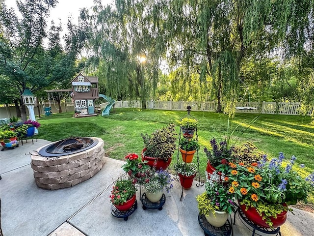16721 Village Garden Dr, Edmond, OK 73012 - view of yard with a playground, a fire pit, a patio area, and view of wooded area