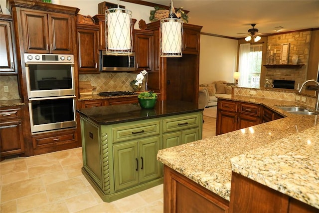 16721 Village Garden Dr, Edmond, OK 73012 - kitchen with appliances with stainless steel finishes, decorative backsplash, a center island, open floor plan, and ceiling fan