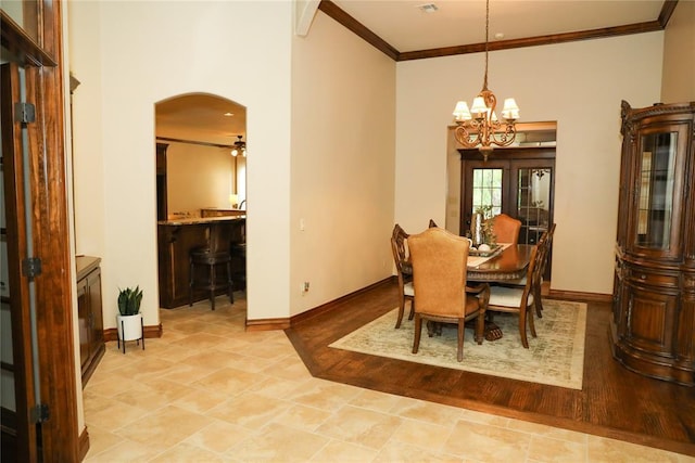 16721 Village Garden Dr, Edmond, OK 73012 - dining room featuring a chandelier, ornamental molding, arched walkways, and a towering ceiling