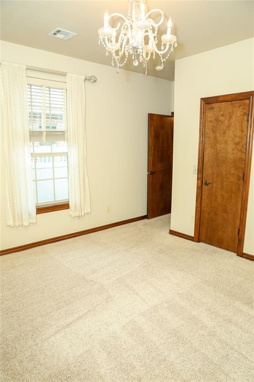 16721 Village Garden Dr, Edmond, OK 73012 - empty room featuring a chandelier and light carpet