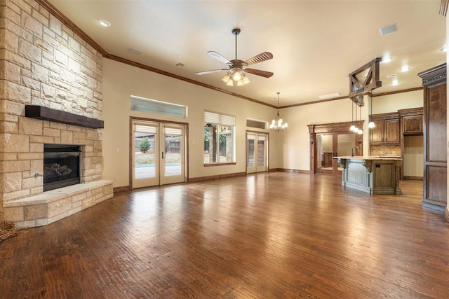2229 Rockbridge Ct, Yukon, OK 73099 - unfurnished living room featuring crown molding, ceiling fan, a fireplace, a chandelier, and wood finished floors