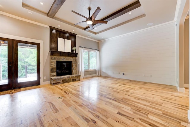 7600 Walk In The Park Dr, Edmond, OK 73034 - unfurnished living room with ceiling fan, light wood finished floors, french doors, a stone fireplace, and arched walkways