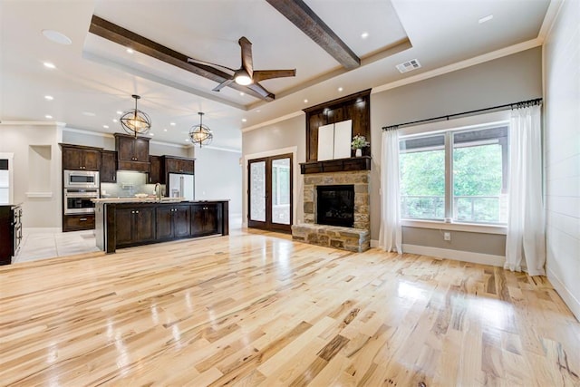 7600 Walk In The Park Dr, Edmond, OK 73034 - unfurnished living room featuring light wood finished floors, a ceiling fan, a stone fireplace, recessed lighting, and ornamental molding