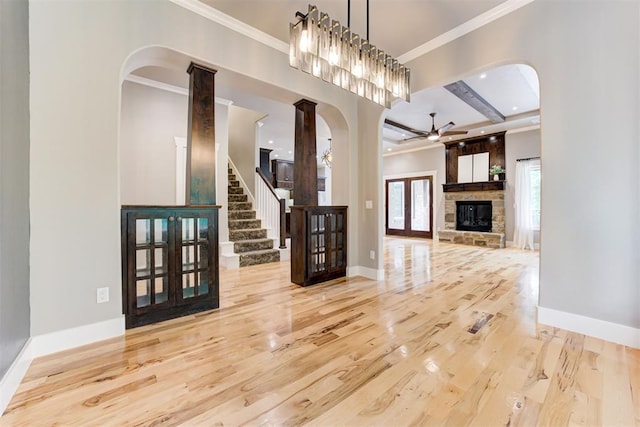 7600 Walk In The Park Dr, Edmond, OK 73034 - unfurnished living room with wood finished floors, arched walkways, ceiling fan, ornamental molding, and a fireplace