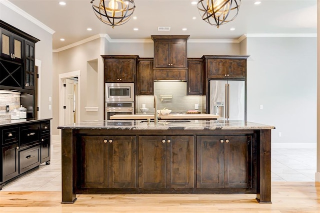 7600 Walk In The Park Dr, Edmond, OK 73034 - kitchen with appliances with stainless steel finishes, a spacious island, recessed lighting, light stone countertops, and tasteful backsplash