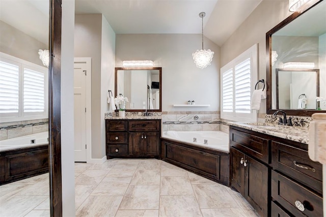 7600 Walk In The Park Dr, Edmond, OK 73034 - bathroom with a bath, two vanities, vaulted ceiling, and a chandelier