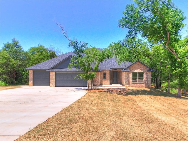 9070 Oak Tree Cir, Edmond, OK 73025 - ranch-style house featuring driveway, an attached garage, and brick siding