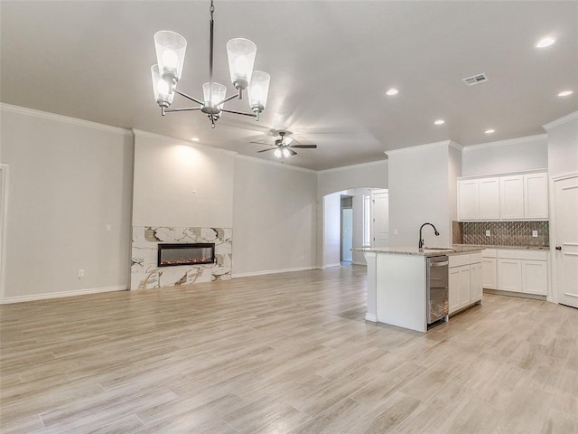 9070 Oak Tree Cir, Edmond, OK 73025 - kitchen with open floor plan, ceiling fan, crown molding, arched walkways, and a kitchen island with sink
