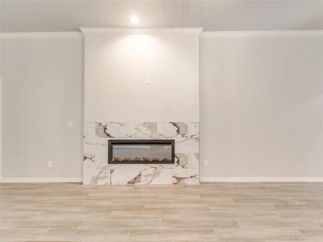 9070 Oak Tree Cir, Edmond, OK 73025 - unfurnished living room with crown molding, a high end fireplace, and wood finished floors