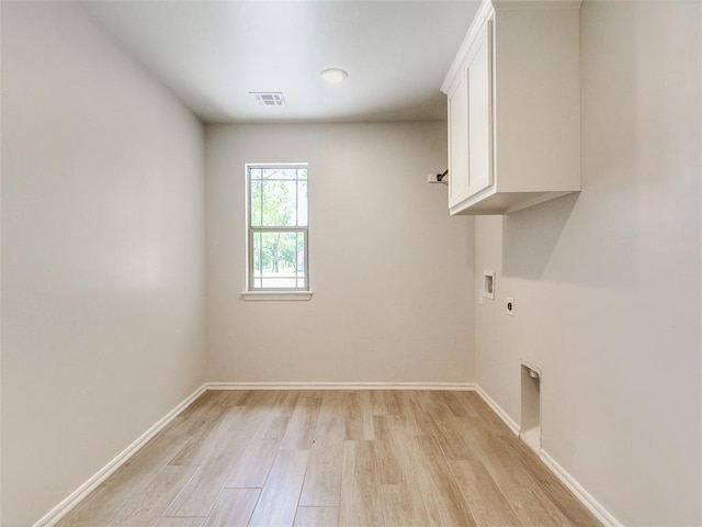 9070 Oak Tree Cir, Edmond, OK 73025 - laundry area featuring electric dryer hookup, cabinet space, light wood-style flooring, and washer hookup