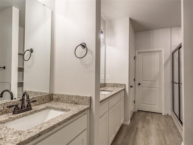 9070 Oak Tree Cir, Edmond, OK 73025 - full bath featuring wood finished floors, two vanities, and a shower stall