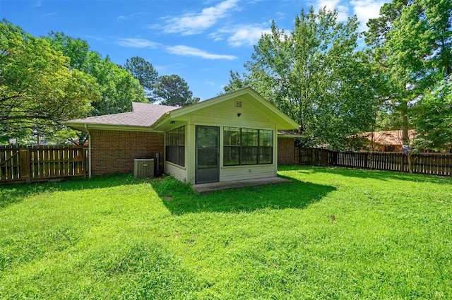 1001 Norris Ave, Broken Bow, OK 74728 - back of property featuring brick siding, a fenced backyard, and a sunroom