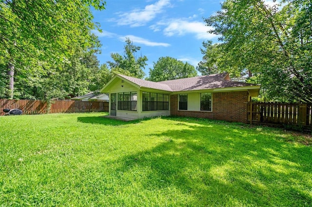 1001 Norris Ave, Broken Bow, OK 74728 - back of property with brick siding, a sunroom, and a fenced backyard