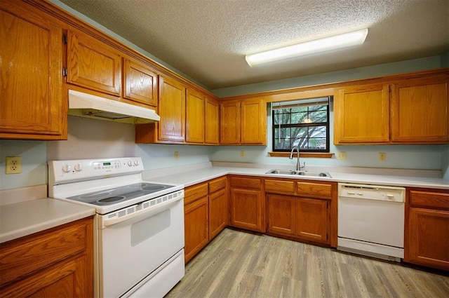 1001 Norris Ave, Broken Bow, OK 74728 - kitchen featuring white appliances, under cabinet range hood, brown cabinetry, and a textured ceiling