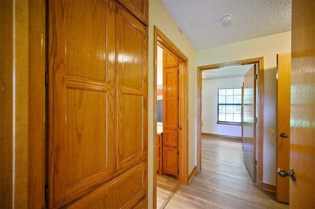 1001 Norris Ave, Broken Bow, OK 74728 - corridor with light wood-type flooring and a textured ceiling