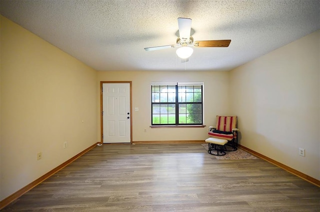 1001 Norris Ave, Broken Bow, OK 74728 - living area featuring wood finished floors, ceiling fan, and a textured ceiling