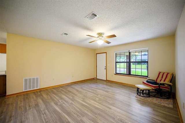 1001 Norris Ave, Broken Bow, OK 74728 - unfurnished room featuring wood finished floors, ceiling fan, and a textured ceiling