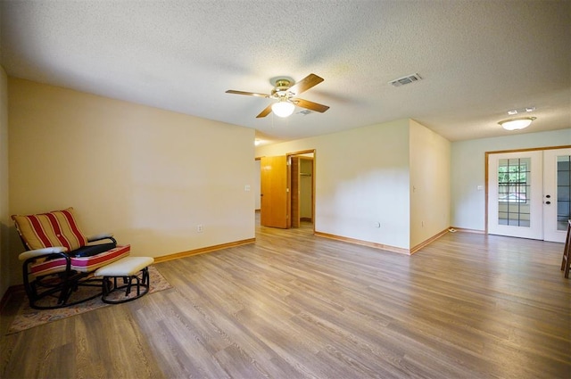 1001 Norris Ave, Broken Bow, OK 74728 - unfurnished room featuring wood finished floors, ceiling fan, a textured ceiling, and french doors