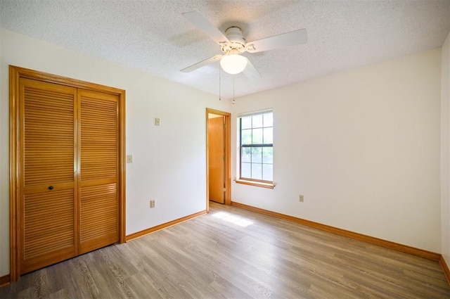 1001 Norris Ave, Broken Bow, OK 74728 - unfurnished bedroom with wood finished floors, a textured ceiling, a closet, and ceiling fan